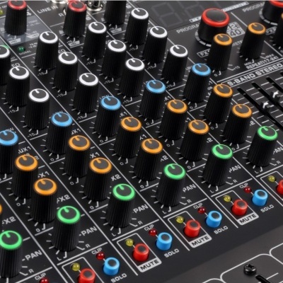 Mesa de mistura de áudio preta com vários botões coloridos e controlos