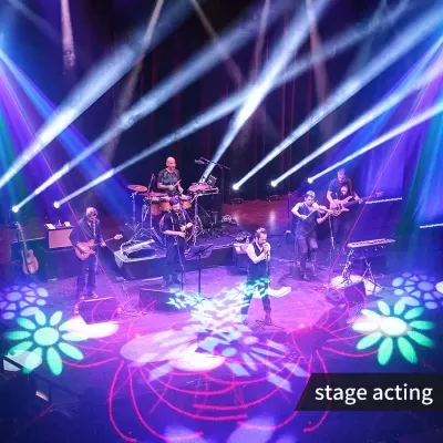 Banda tocando ao vivo num palco iluminado com efeitos coloridos e texto stage acting