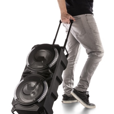 Coluna de som portátil preta com rodas e pega extensor puxada por uma pessoa