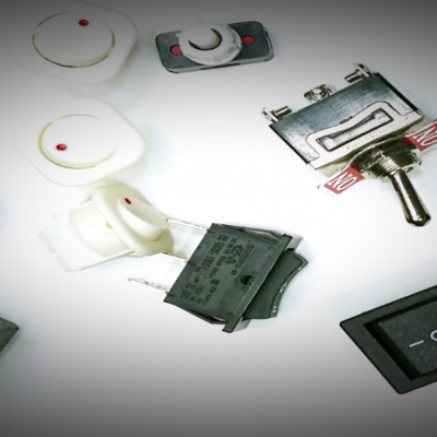 interruptores e botões elétricos variados sobre superfície branca