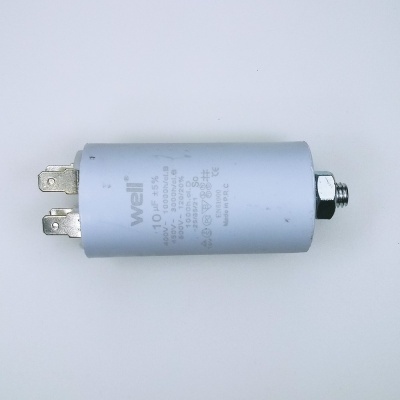 Condensador eletrônico cinza com conectores metálicos e texto técnico impresso.