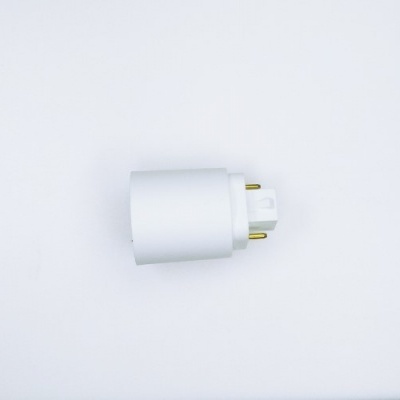 Ficha elétrica branca com pinos dourados sobre superfície branca