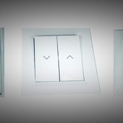Três interruptores de parede brancos com símbolos de setas num deles.