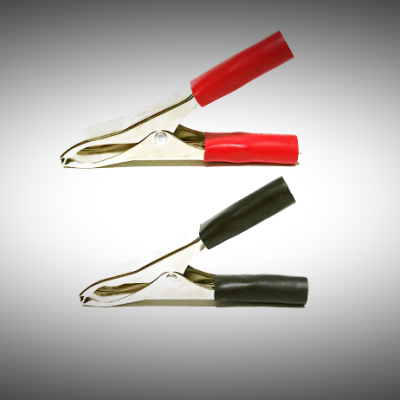 Par de garras de crocodilo metálicas com tampas vermelha e preta sobre fundo branco com borda preta