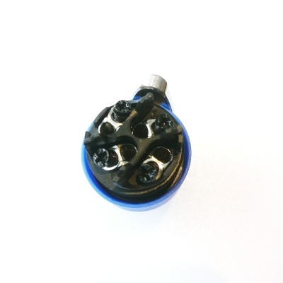 Objeto redondo azul e preto com orifícios e parafusos sobre fundo branco