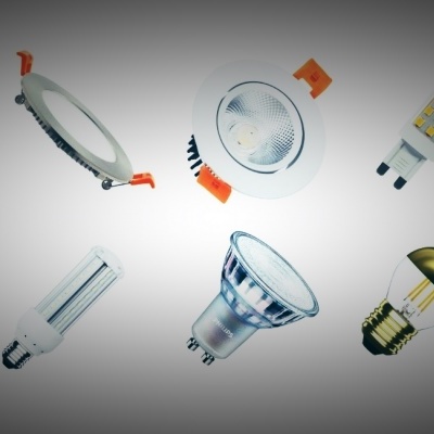 Diferentes lâmpadas LED e fita LED em carretel sobre fundo cinza