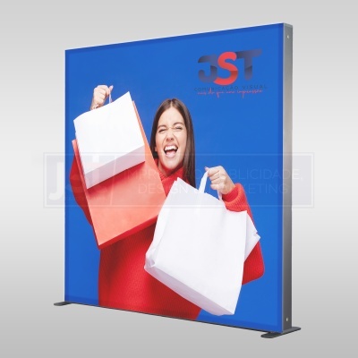 Expositor publicitário com imagem de mulher a segurar sacos de compras em fundo azul
