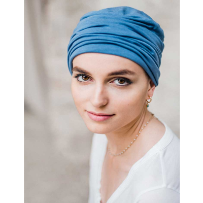 Mulher com turbante azul e camisa branca
