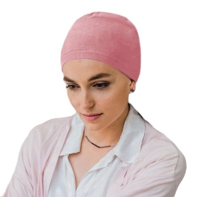 Mulher com gorro rosa e roupa clara em fundo branco