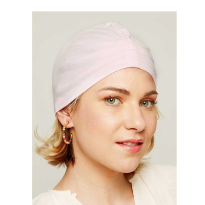 Mulher com touca rosa clara e brincos coloridos de argola