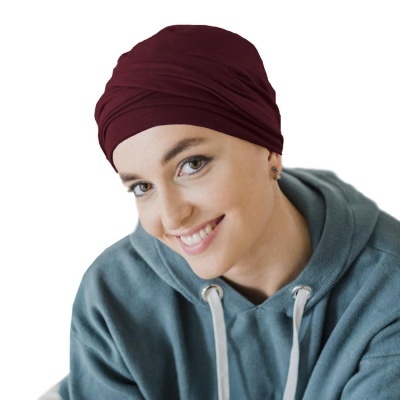 Mulher com lenço bordeaux e sweat azul esverdeado