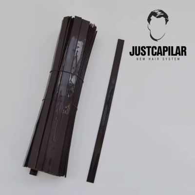 Tiras pretas flexíveis e logo JUSTCAPILAR NEW HAIR SYSTEM em fundo branco