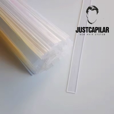 Tubos transparentes empilhados com logo JUSTCAPILAR NEW HAIR SYSTEM ao lado