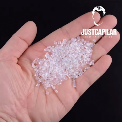 Mão com pequenos grânulos transparentes em cubo