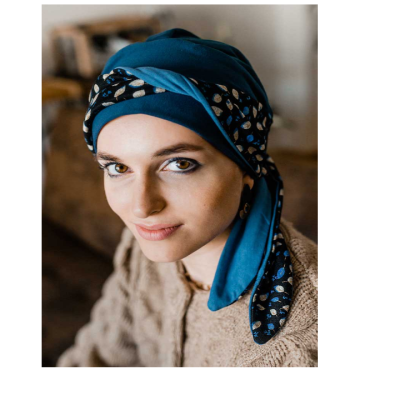 Lenço azul com padrão em cabeça de mulher, ambiente interior desfocado