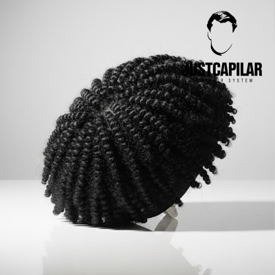 Peruca de caracóis pretos sobre suporte branco com logótipo JUSTCAPILAR HAIR SYSTEM