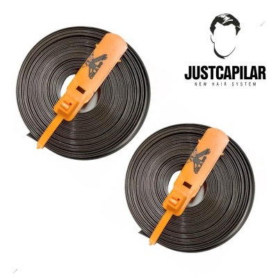 Dois rolos de fita preta com mecanismo laranja e logo JUSTCAPILAR