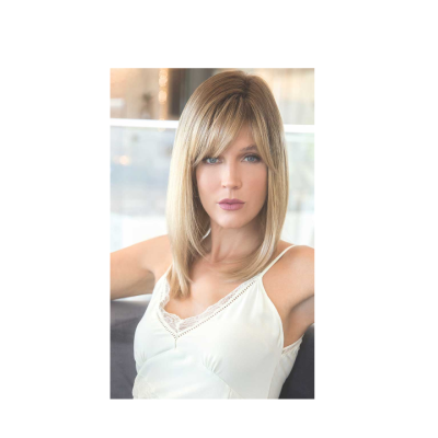 Mulher loira de cabelo médio com top branco sentada num sofá cinzento