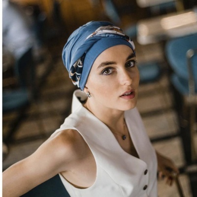 Mulher com lenço azul na cabeça e vestido branco