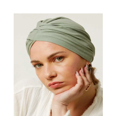 Lenço de cabeça verde claro com dobras enroladas em mulher com blusa branca