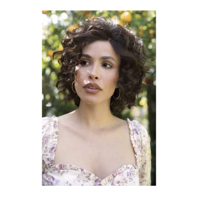 Mulher com vestido floral e cabelo encaracolado ao ar livre