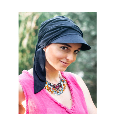 Mulher com lenço preto tipo turbante e vestido rosa