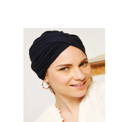 Mulher a usar touca preta de tecido e brincos de argola coloridos