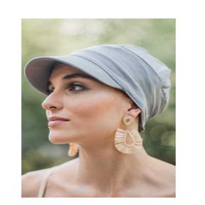 Mulher com chapéu cinzento claro e brincos grandes de material natural