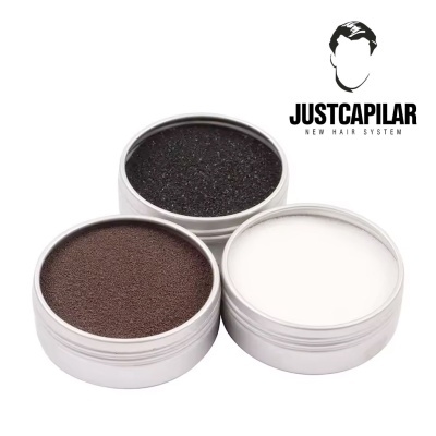 Três latas metálicas com pomadas preta, castanha e branca ao lado do logo JUSTCAPILAR