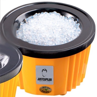 Recipiente amarelo e preto com bolas brancas translúcidas e etiqueta JUSTCAPILAR
