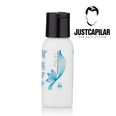 Frasco branco com tampa preta e design azul de champô JustCapilar num fundo branco.