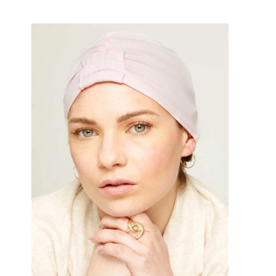 Mulher com faixa de cabeça rosa clara e roupas claras