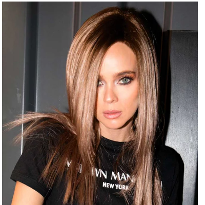 Mulher com cabelo liso castanho claro e t-shirt preta com texto 'NEW YORK'