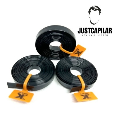 Três rolos de fita preta com etiquetas laranja e logótipo JUSTCAPILAR