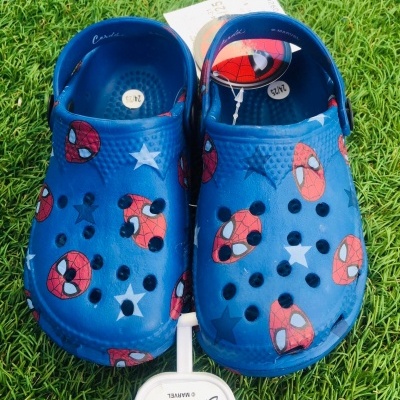 Calçado azul com estampas do Homem-Aranha sobre relva