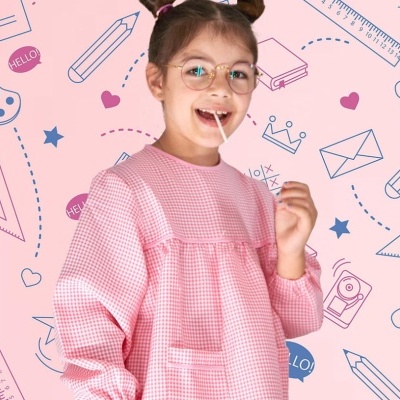 Menina com bata rosa às quadrículas em fundo cor de rosa com desenhos escolares