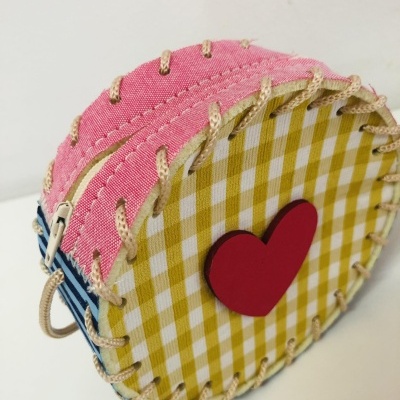 Bolsa redonda com padrão xadrez amarelo e branco e coração vermelho