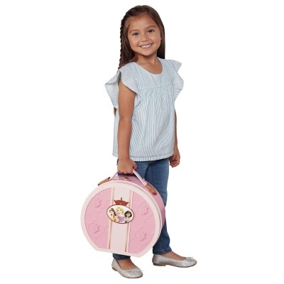 Menina com blusa azul e mala cor-de-rosa redonda com personagens de desenho