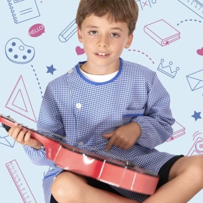 Menino com camisola azul às quadrículas segura ukulele vermelho sentado