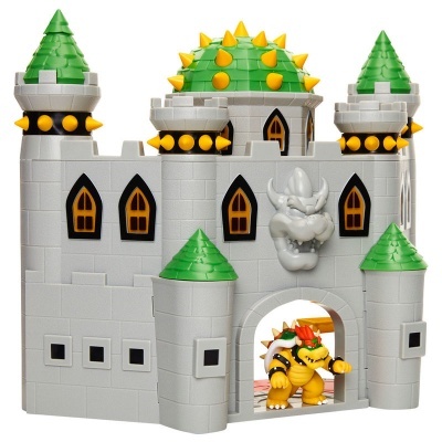 Castelo de brinquedo cinzento com torres verdes e figura amarela na entrada