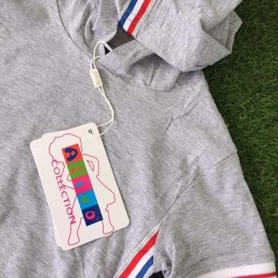 Camisola cinza com capuz e riscas vermelha, branca e azul, etiqueta 'DAVID COLLECTION', sobre relva verde