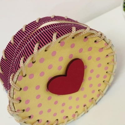Caixa redonda decorativa amarela com pontos cor-de-rosa e coração vermelho na tampa