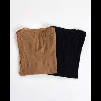 Duas t-shirts dobradas, uma castanha clara e outra preta, lado a lado