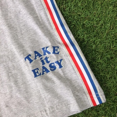 Tecido cinzento com faixa lateral tricolor e texto bordado 'TAKE it EASY'