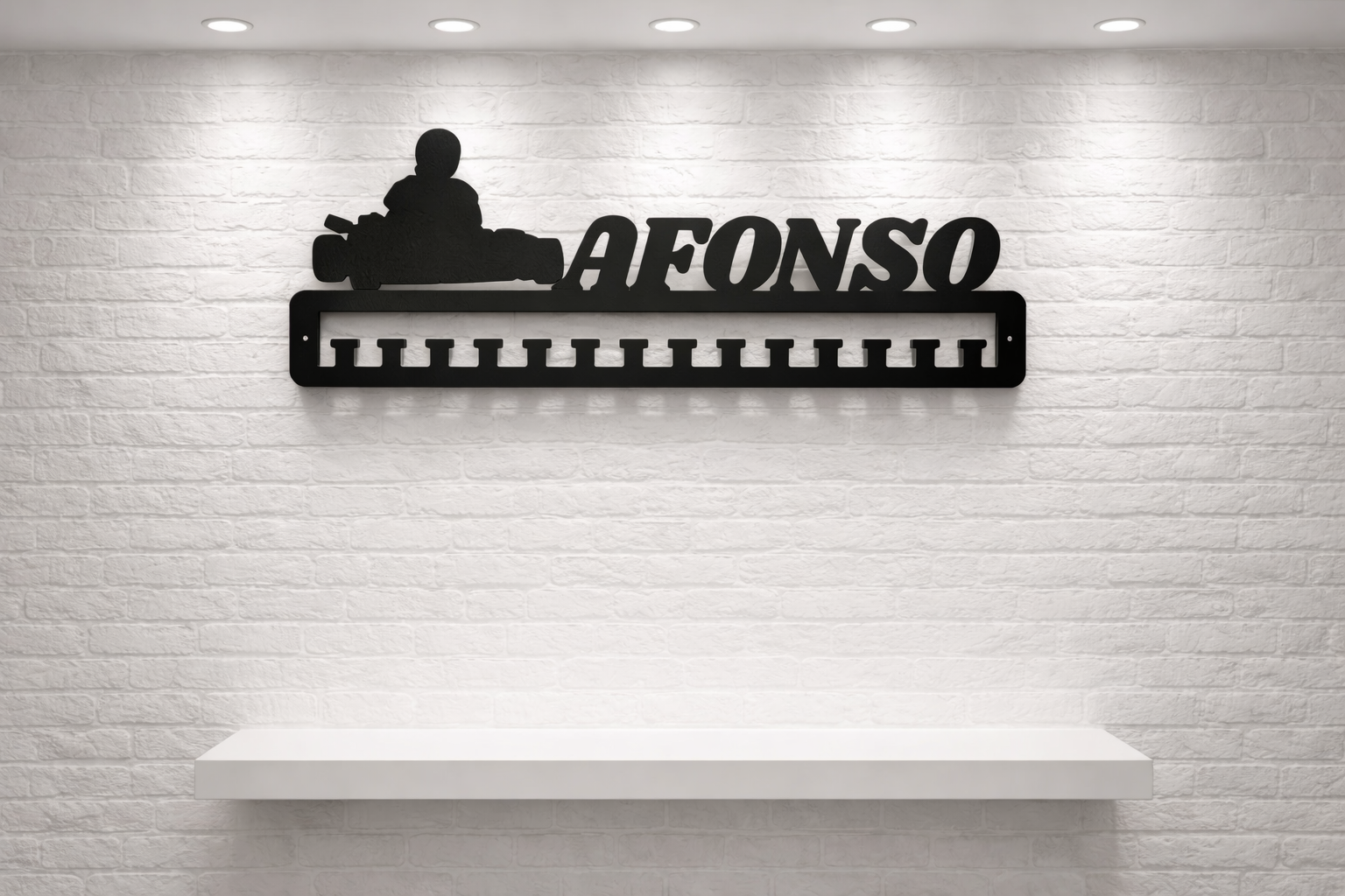 Suporte preto para medalhas com nome AFONSO e piloto de kart, parede tijolo branco.