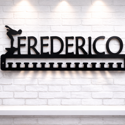 Suporte de medalhas preto com nome Frederico e figura de saltador em parede branca