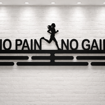 Medalhanger de metal preto com frase motivacional montado em parede de tijolo branco