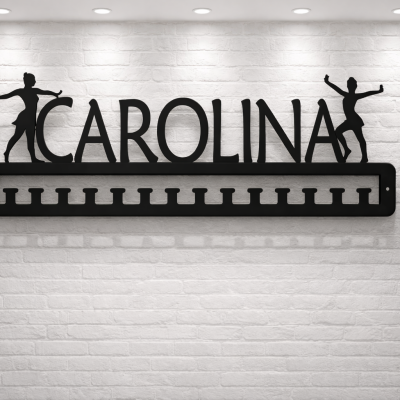 Organizador de medalhas preto com bailarinas e nome Carolina numa parede branca