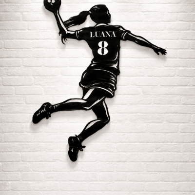 Escultura de parede de jogadora de andebol em metal preto com o nome LUANA e número 8 numa parede branca de tijolos.