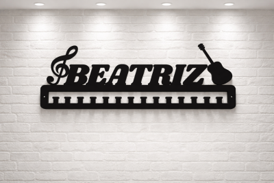 Suporte de parede preto em metal com a palavra BEATRIZ e elementos musicais